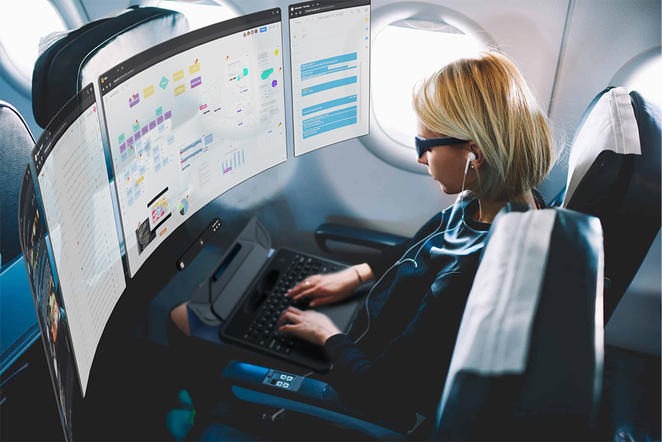 Photo of a woman using Spacetop on an airline flight, with multiple windows and apps open around her